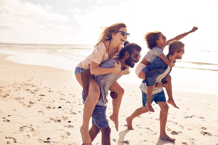 Two men race while carrying their girlfriends piggyback