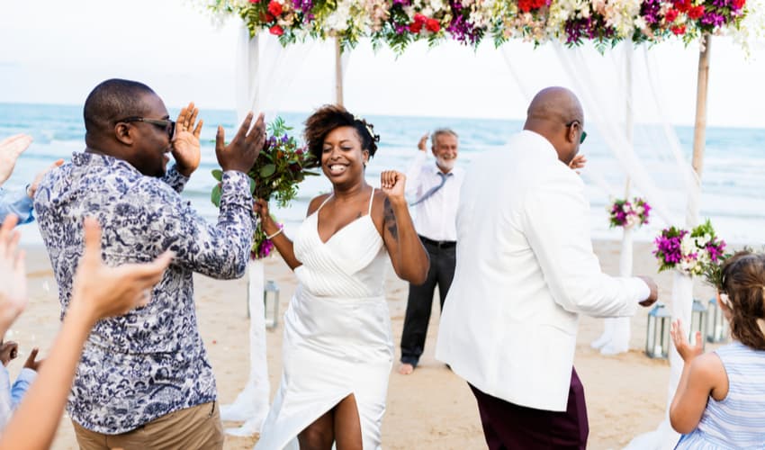 A couple dancing and celebrating during a beach wedding