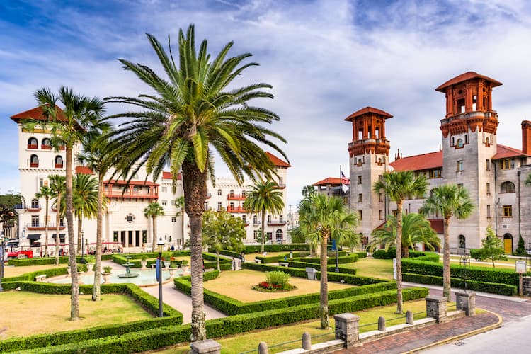 Town square of St. Augustine Florida filled with palm trees, a garden, and Spanish architecture