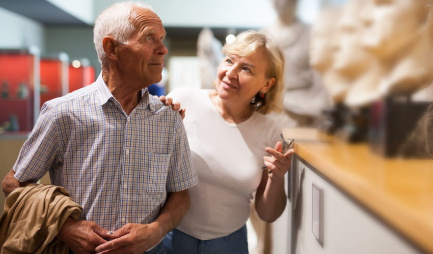 an older woman and man explore a museum and talk