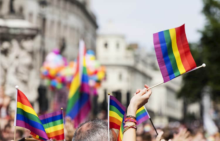 parade-goers wave rainbow flags during pride