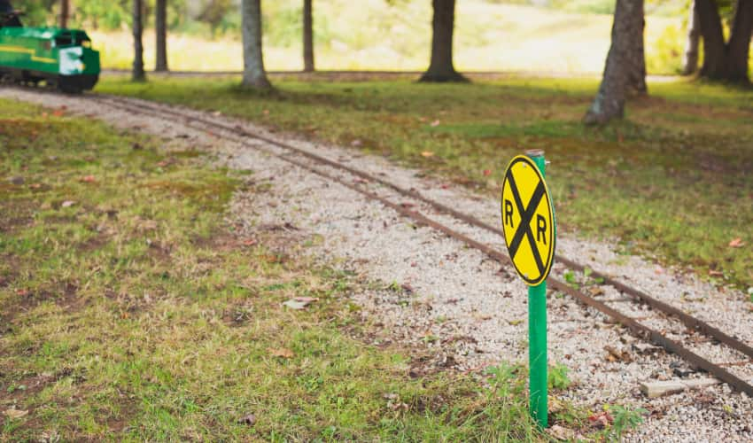 A miniature train track cuts through a park