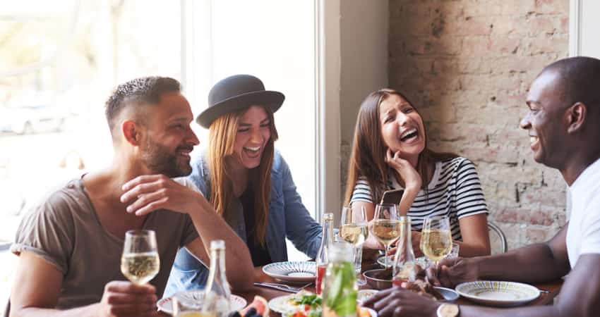 A diverse group of friends having a meal with champagne 