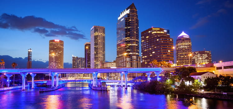 the tampa skyline after dark, with the city lights illuminating the river