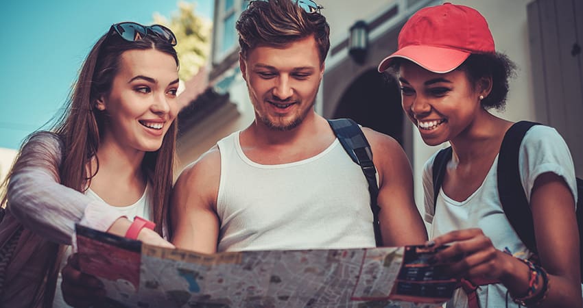 a group of tourists consult a map while walking in a city