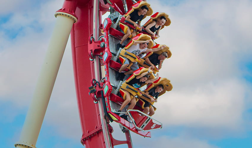 people cheer as they ride a roller coaster