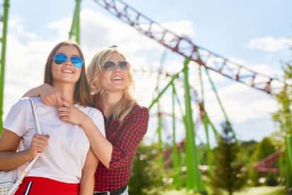 two women affectionately holding eachother at a theme park