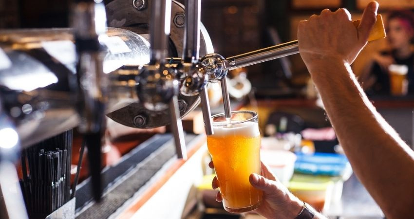 Bartender pours beer from tap