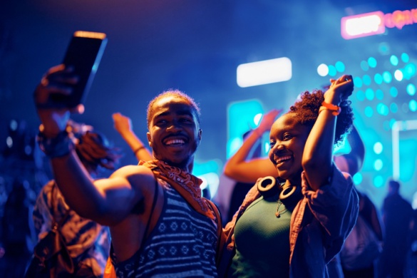 two friends dance and take pictures at a concert