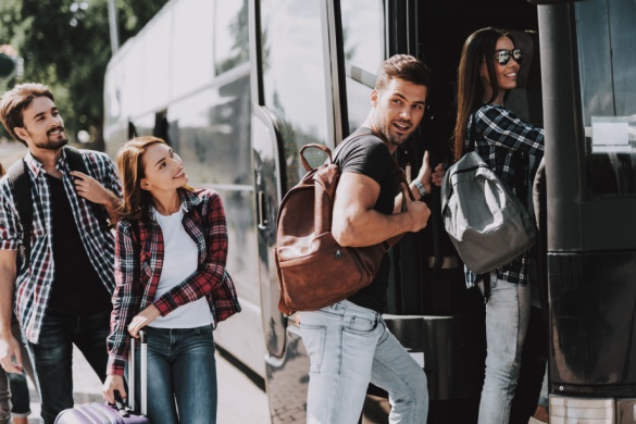 a group of passengers boards a charter bus
