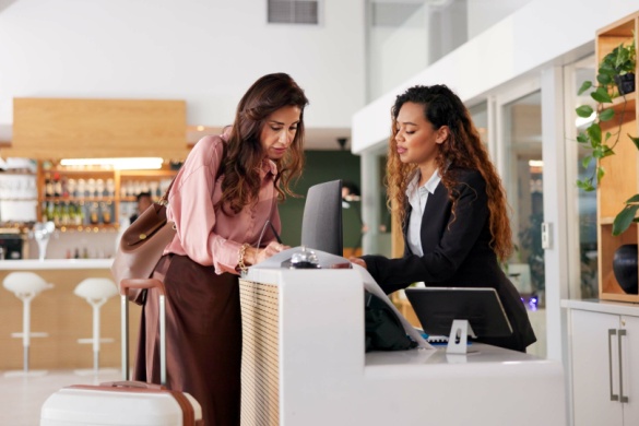 a hotel worker helps a guest check in