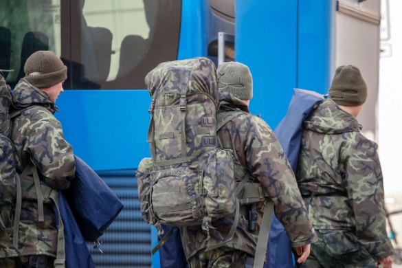 a group of soldiers board a charter bus